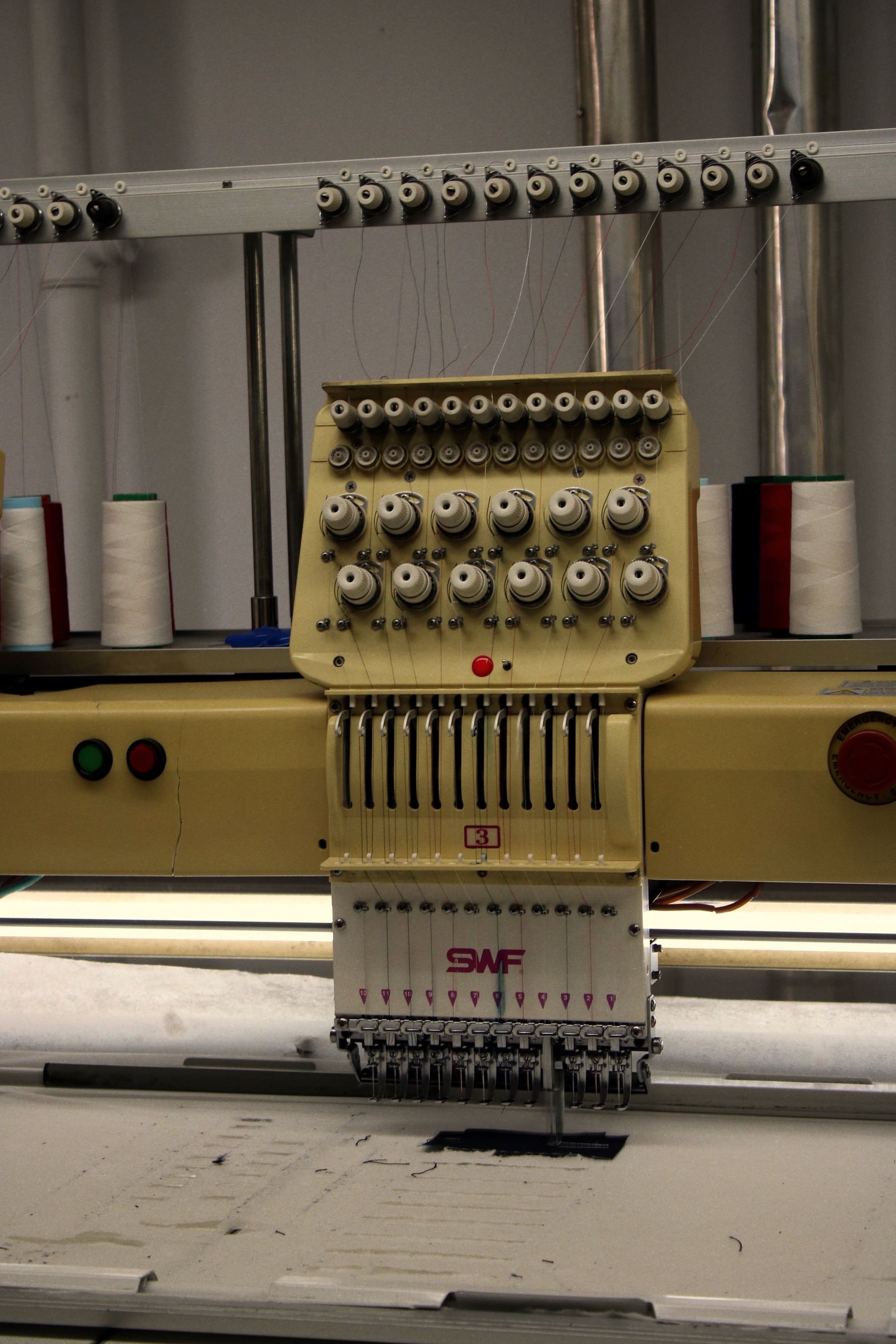 Embroidery machine stitching a custom logo for branded apparel